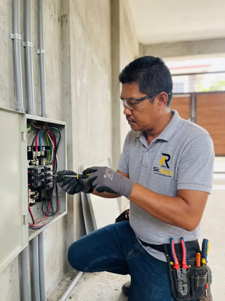 Selbor, a TESDA certified electrician, working on an electrical panel in Tagaytay